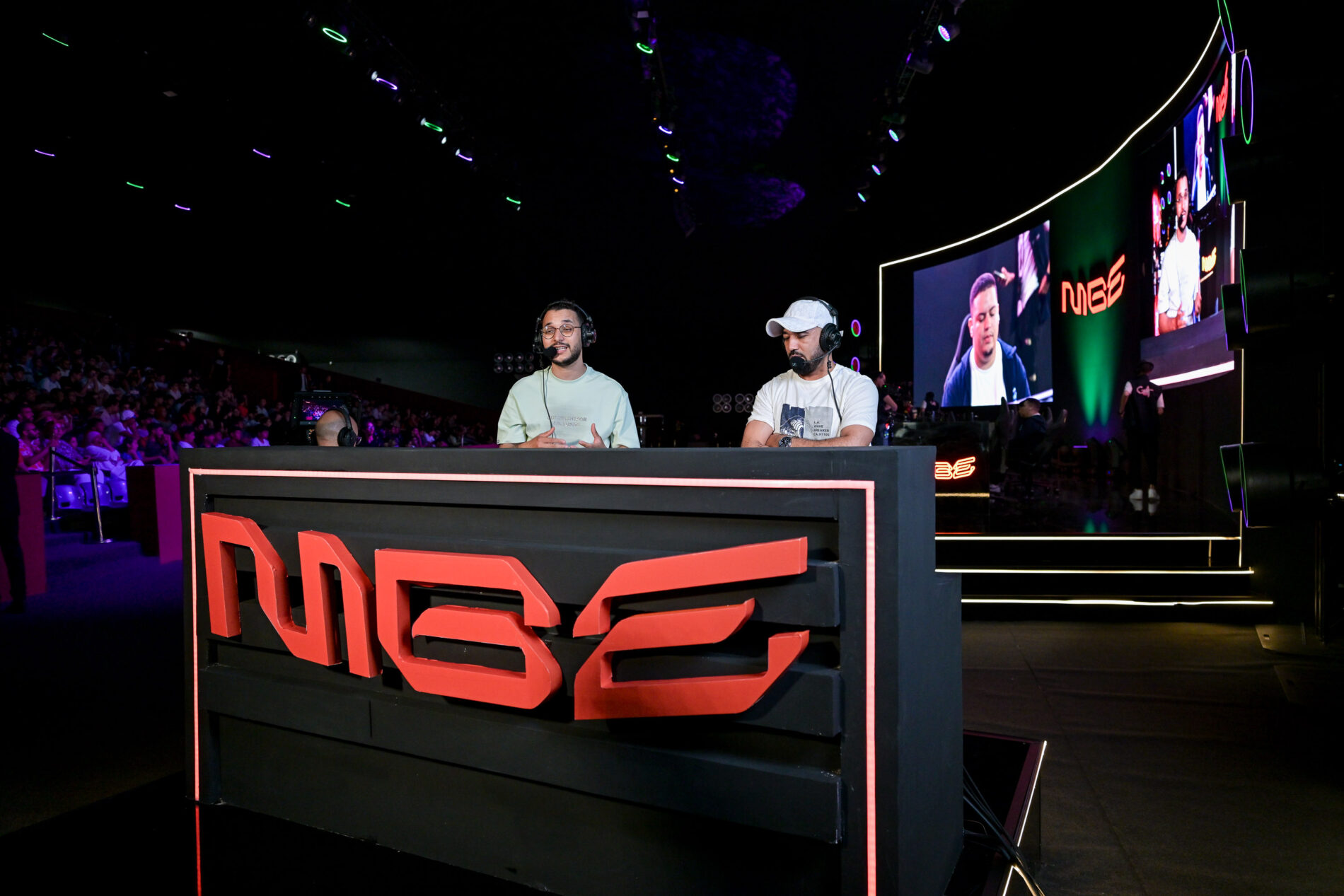 Commentateurs e-sport avec casques et micros analysant un match de EA Sports FC sur le pupitre MGE-EAFC2026